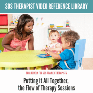 Therapist engaging with two toddlers at a colorful play table, promoting healthy eating habits.